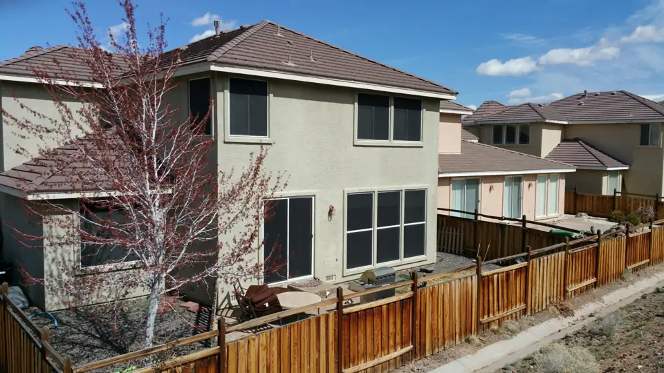 Solar screens installed on the back windows of a two-story home