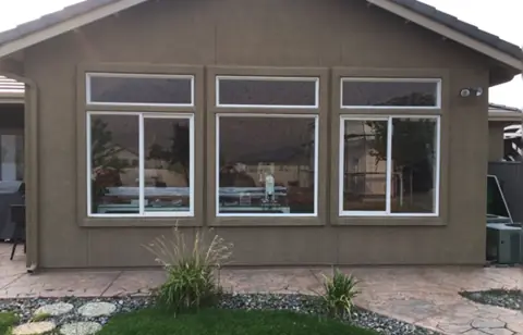 Before: Rear windows of a stucco home, solar screens